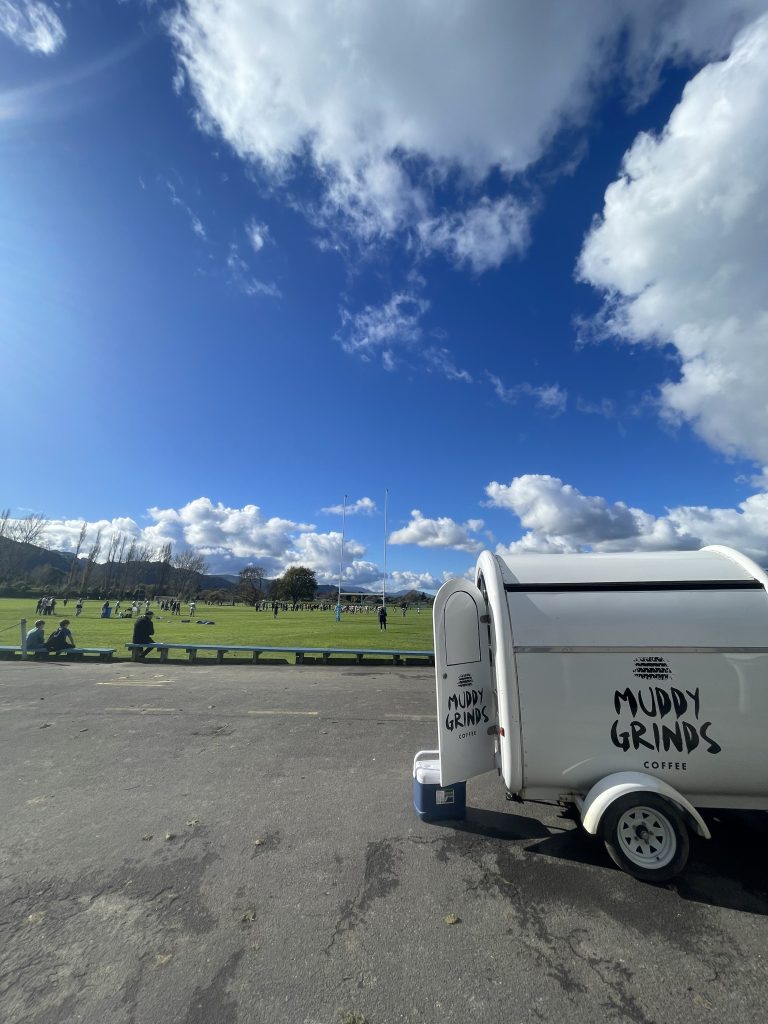 a photo of a sports ground with a white trailer in the foreground
