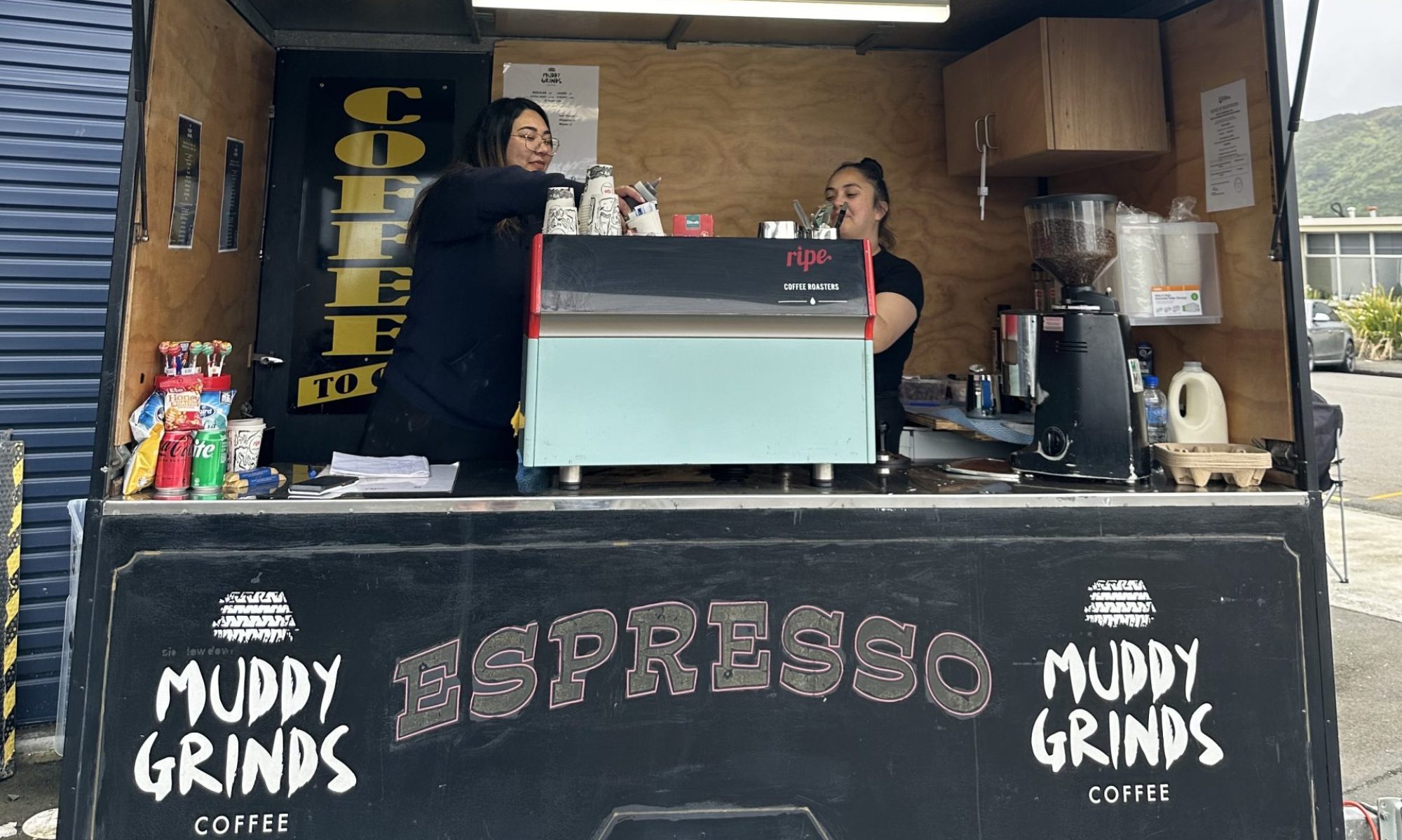 a photo of a coffee cart with two women in the back working